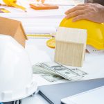 cropped-image-architect-holding-work-helmet-table-office